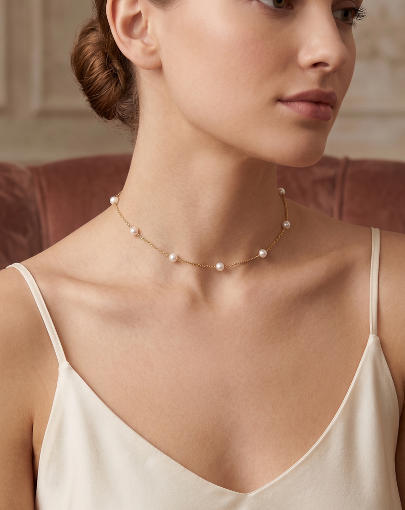 Model wearing gold floating pearl station necklace with cream top