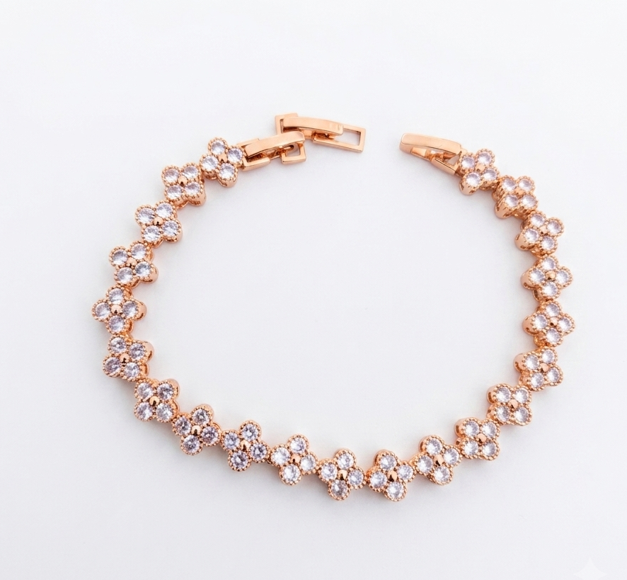 Rose gold clover flower bracelet flat lay on white background