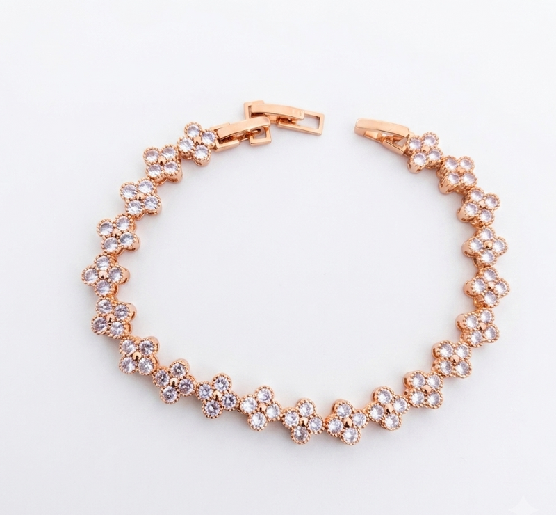 Rose gold clover flower bracelet flat lay on white background