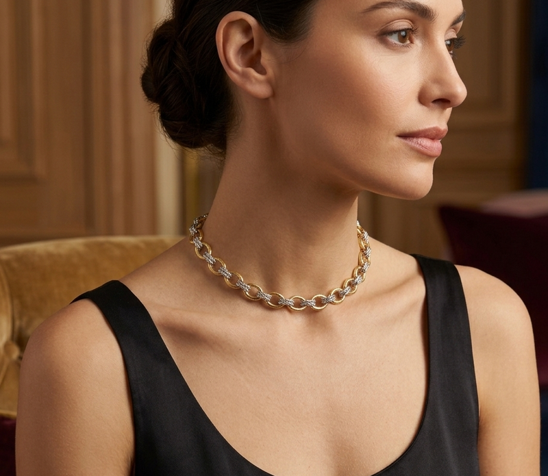 Model wearing two-tone oval link chain necklace with black dress