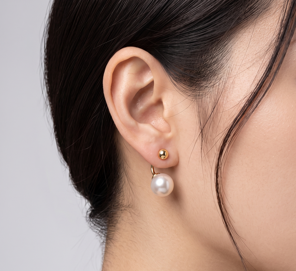 Gold ball and pearl jacket earrings worn on model