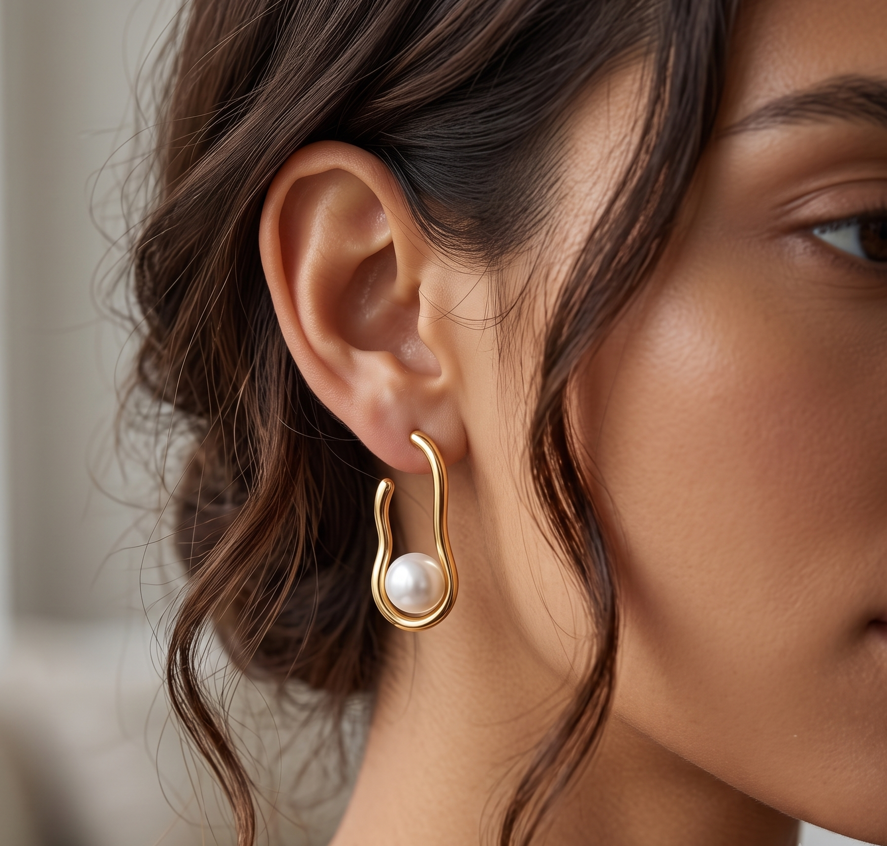 Gold sculptural pearl hoop earrings product shot
