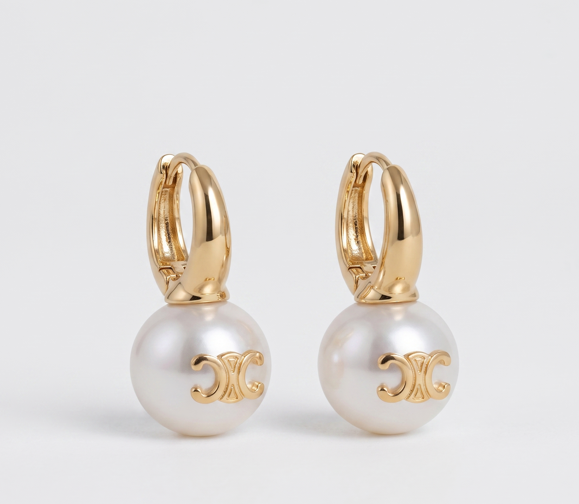 Gold huggie pearl charm earrings product shot