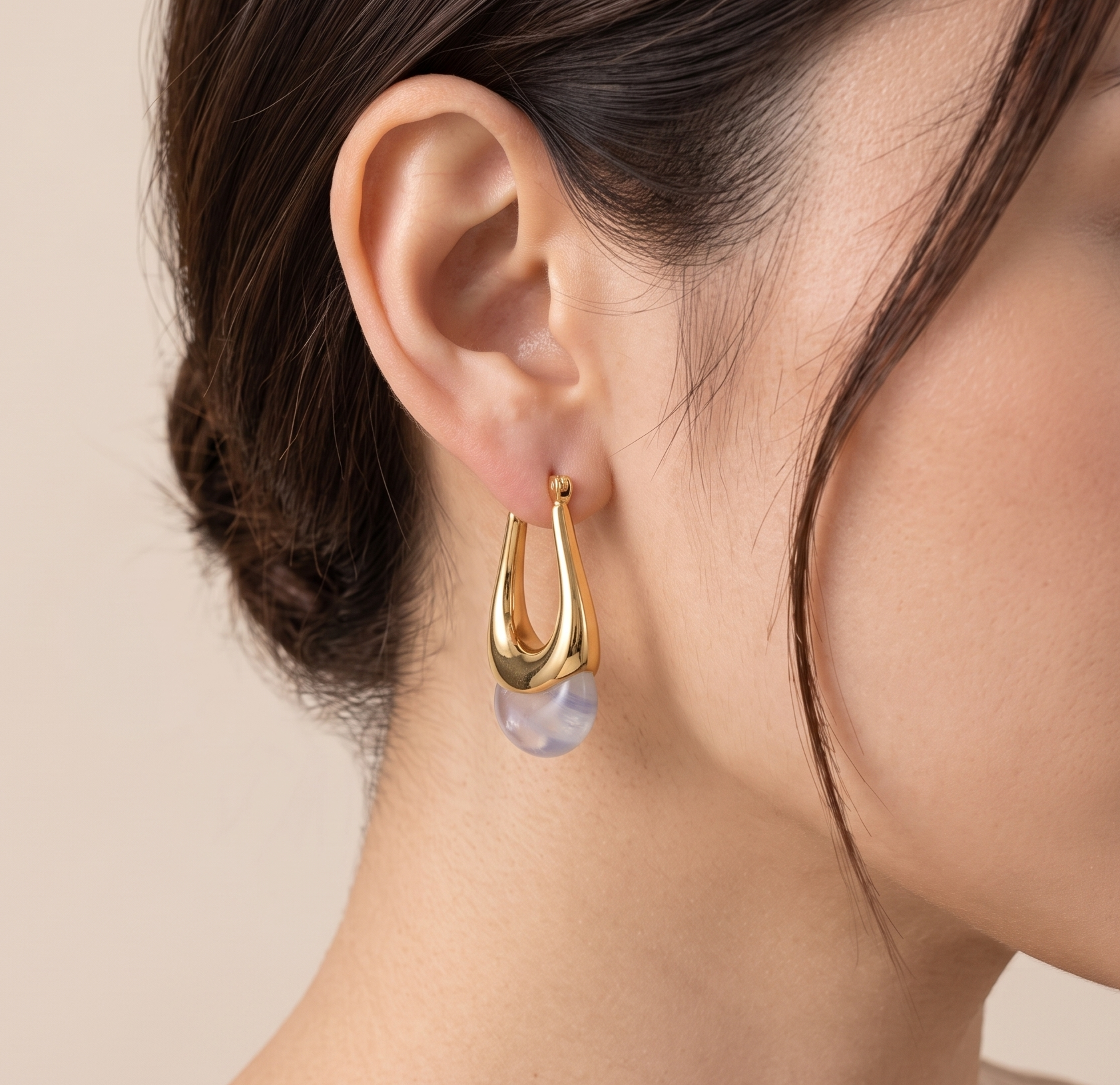 Gold arch moonstone drop earrings worn on model