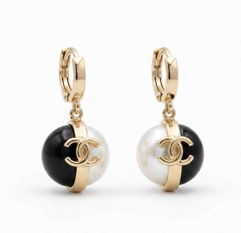 Gold hoop pearl and onyx drop earrings worn on model