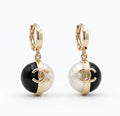 Gold hoop pearl and onyx drop earrings worn on model